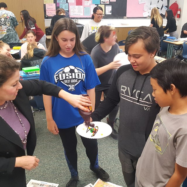 Students participate in a scientific experiment with delectable cake.