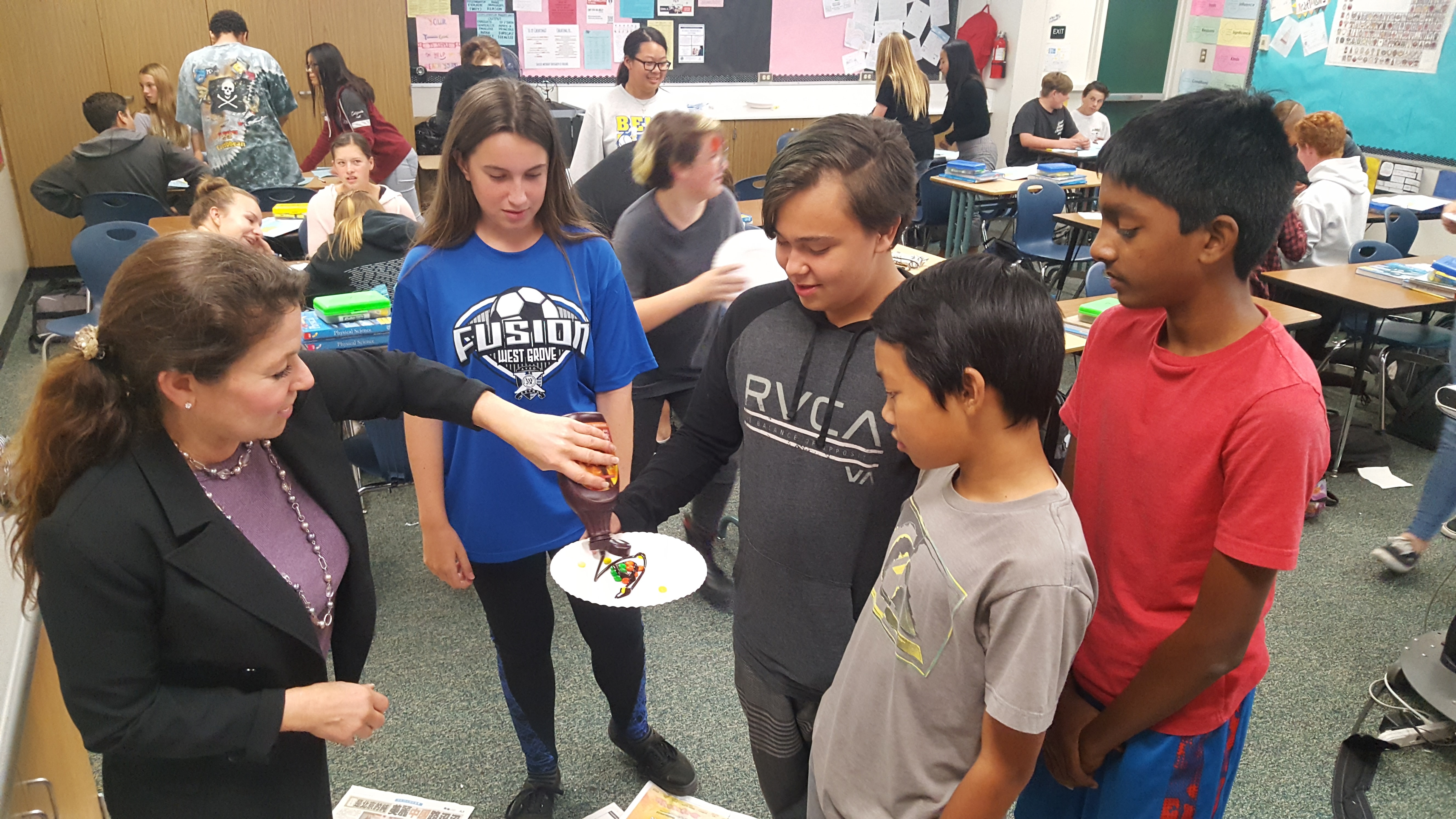 Students participate in a scientific experiment with delectable cake.